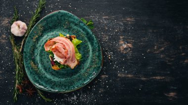 Kahvaltı. Haşlanmış yumurta, pastırma marul tost yaptı. Siyah ahşap arka plan üzerinde. Kopya alanı.