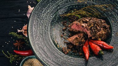 Biberli biftek gelen sığır eti. Et. Sıcak meze. Üstten Görünüm. Siyah ahşap arka plan üzerinde. Kopya alanı.