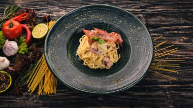 Carbonara Yapıştır. İtalyan mutfağı. Üstten Görünüm. Siyah ahşap arka plan üzerinde. Kopya alanı.
