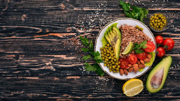健康食品 チェリー トマト アボカド アーモンド グリーン ピース 木製の背景 平面図です テキストの無料スペース — ストック写真