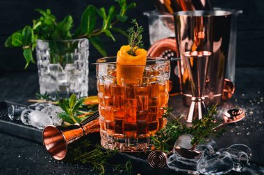 Alkol kokteyl Negroni. Orange, likör, buz. Siyah bir ahşap arka plan üzerinde.