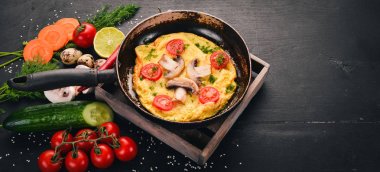 Mantar ve taze sebze ve fındık bir tavada omlet. Ahşap bir arka plan üzerinde. Üstten Görünüm. Kopya alanı.