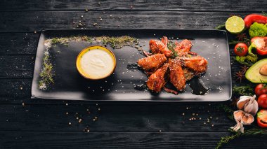 Tavuk kanadı ızgara biftek ve peynir sos ile. Üstten Görünüm. Siyah ahşap arka plan üzerinde. Kopya alanı.