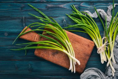 Fresh green onion on a wooden background. Top view. Free space for your text. clipart