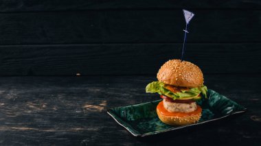 Mini hamburger tavuk fileto ile. Üstten Görünüm. Siyah ahşap arka plan üzerinde. Kopya alanı.