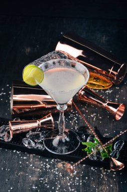 Alkol kokteyl Margarita. Tekila, kireç, buz. Siyah arka plan çubuğunda.