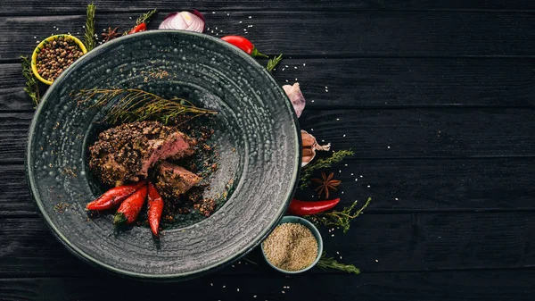 Biberli biftek gelen sığır eti. Et. Sıcak meze. Üstten Görünüm. Siyah ahşap arka plan üzerinde. Kopya alanı.