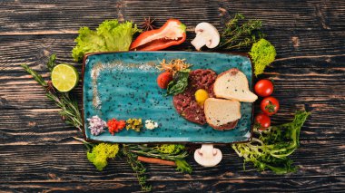 Bıldırcın yumurta beef tartar. Soğuk aperatifler. Siyah ahşap arka plan üzerinde. Kopya alanı.