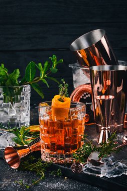 Alkol kokteyl Negroni. Orange, likör, buz. Siyah bir ahşap arka plan üzerinde.
