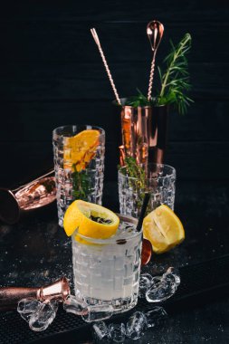 Fiesta alkollü kokteyl. Sambuca likör, tonik, limon. Siyah bir ahşap arka plan üzerinde.