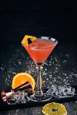 Alkol kokteyli Cosmopolitan. Siyah arka plan çubuğunda.