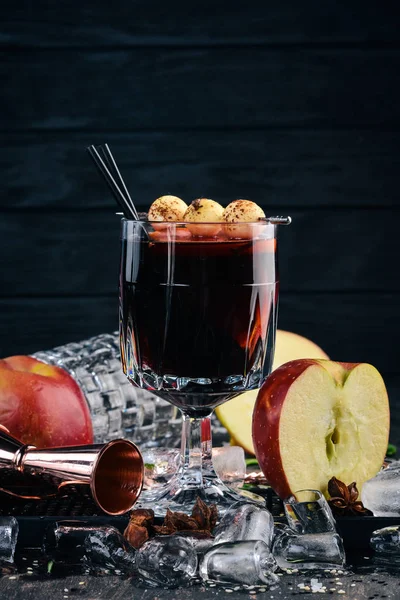 A cocktail of hot red wine. Wine. On a black wooden background.