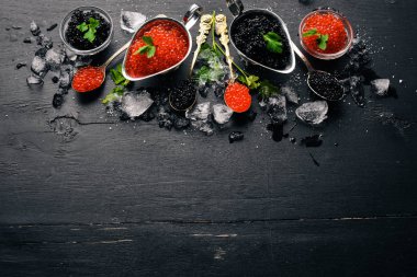 Ahşap arka plan üzerinde siyah ve kırmızı havyar kaşıkla. Üstten Görünüm. Metin için boş alan.