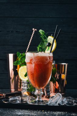 Alkollü kokteyl Bloody Mary. Biberiye ve domates suyu. Siyah bir ahşap arka plan üzerinde.