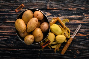 Çiğ patates. Kahverengi ahşap zemin üzerinde. Yemek. Metin için özgür yer. Üstten Görünüm.