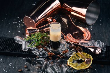 Alkollü kokteyl B-52. Bar. Siyah bir ahşap arka plan üzerinde.