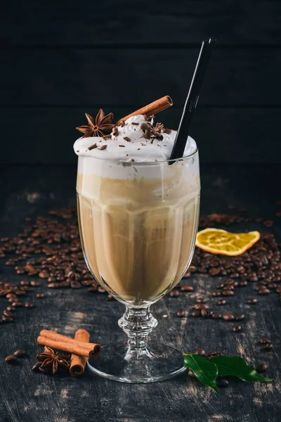 Fragrant coffee cup Frappe with ice cream and caramel. On a black wooden background. Top view. Copy space.