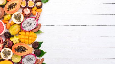 Tropikal meyveler, papaya, Dragon meyve, rambutan, demirhindi, kaktüs meyve, avokado, granadilla, carambola, Kamkat, mango, mangosten, Çarkıfelek, Hindistan cevizi. Ahşap bir arka plan üzerinde.