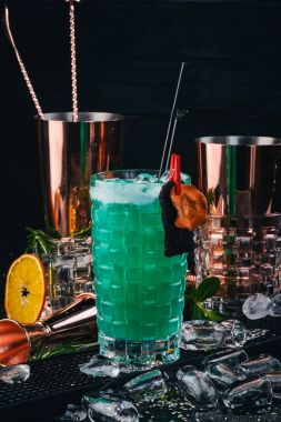 Alkol kokteyl mavi lagün. Orange, likör, buz. Siyah bir ahşap arka plan üzerinde.