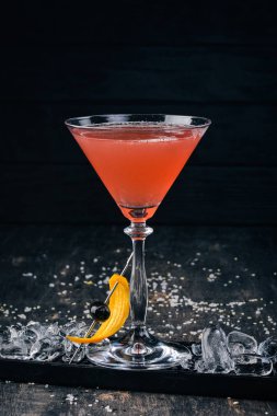 Alkol kokteyli Cosmopolitan. Siyah arka plan çubuğunda.