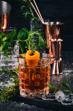 Alkol kokteyl Negroni. Orange, likör, buz. Siyah bir ahşap arka plan üzerinde.