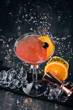 Alkol kokteyli Cosmopolitan. Siyah arka plan çubuğunda.