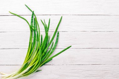 Ahşap arka plan üzerinde taze yeşil soğan. Üstten Görünüm. Metniniz için boş alan.