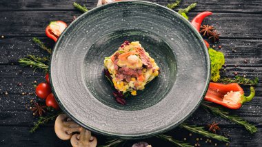 Sığır eti ve karides Olivier salatası. Üstten Görünüm. Siyah ahşap arka plan üzerinde. Kopya alanı.