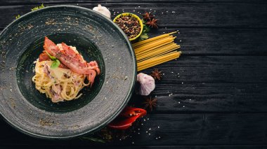 Carbonara Yapıştır. İtalyan mutfağı. Üstten Görünüm. Siyah ahşap arka plan üzerinde. Kopya alanı.