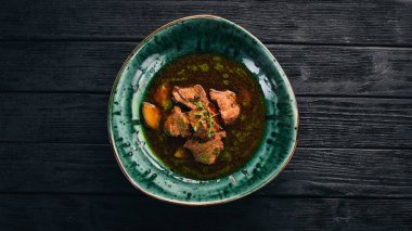 Sığır eti ve sebze çorbası. Üstten Görünüm. Siyah ahşap arka plan üzerinde. Kopya alanı.