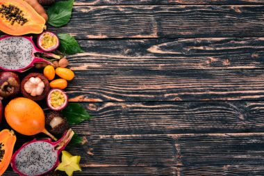 Tropikal meyveler, papaya, Dragon meyve, rambutan, demirhindi, kaktüs meyve, avokado, granadilla, carambola, Kamkat, mango, mangosten, Çarkıfelek, Hindistan cevizi. Ahşap bir arka plan üzerinde.