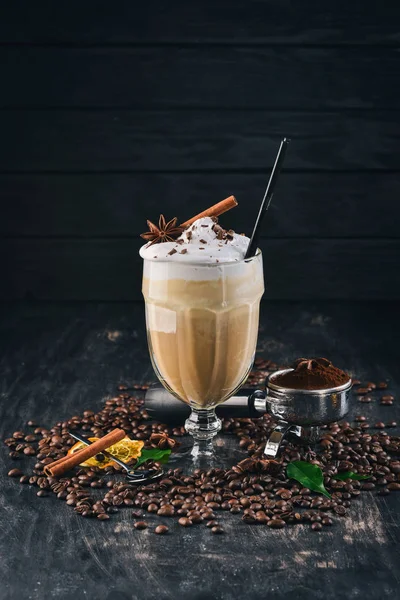 Fragrant coffee cup Frappe with ice cream and caramel. On a black wooden background. Top view. Copy space.