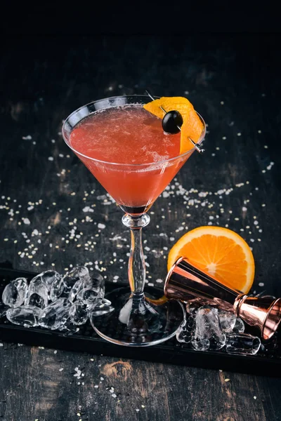 Alkol kokteyli Cosmopolitan. Siyah arka plan çubuğunda.