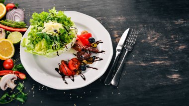 Domates, roka ve füme domates salatası. Ahşap bir arka plan üzerinde. Üstten Görünüm. Kopya alanı.