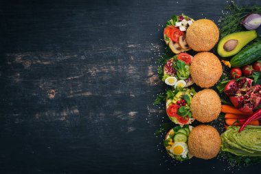 Burger ayarla, sandviç. Bıldırcın yumurta, salatalık ve Mısır, salam ve deniz ürünleri ile. Ahşap bir arka plan üzerinde. Üstten Görünüm. Kopya alanı.