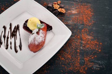 Tatlı. Karamelize armut bir plaka üzerinde dondurma ile. Ahşap bir arka plan üzerinde. Üstten Görünüm. Kopya alanı.