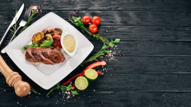 Domuz eti biftek bir plaka üzerinde ızgara sebzeler ile. Ahşap bir arka plan üzerinde. Üstten Görünüm. Kopya alanı.