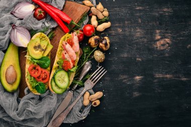 Burger, karides, avokado, havyar ve salatalık sandviç. Ahşap bir arka plan üzerinde. Üstten Görünüm. Kopya alanı.