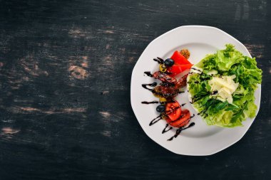 Domates, roka ve füme domates salatası. Ahşap bir arka plan üzerinde. Üstten Görünüm. Kopya alanı.