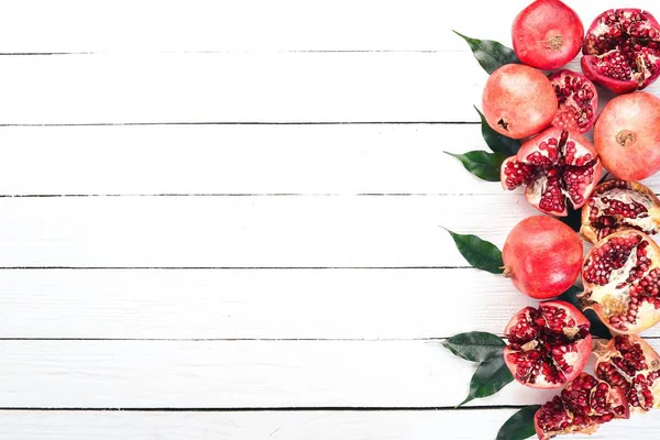 Nar. Beyaz ahşap zemin üzerinde. Üstten Görünüm. Kopya alanı.