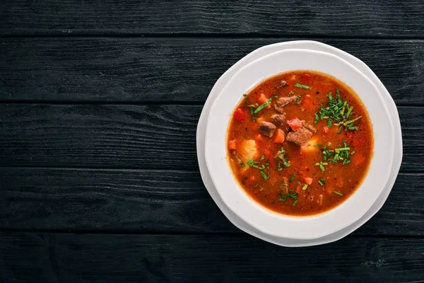 Soup with beef tomatoes and fresh vegetables. On a wooden background. Top view. Copy space. — Stock Image Soup Beef Tomatoes Fresh Vegetables Wooden Background Top View Copy Stock Image