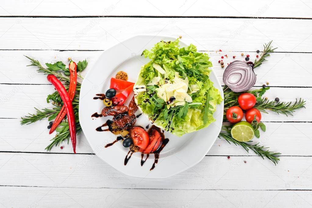 Salad with tomatoes, arugula and smoked tomatoes. On a wooden background. Top view. Copy space.