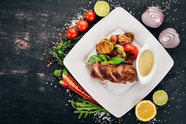 Domuz eti biftek bir plaka üzerinde ızgara sebzeler ile. Ahşap bir arka plan üzerinde. Üstten Görünüm. Kopya alanı.