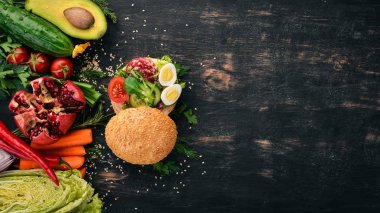 Hamburger, sandviç salam, bıldırcın yumurtası ve kiraz domates. Ahşap bir arka plan üzerinde. Üstten Görünüm. Kopya alanı.