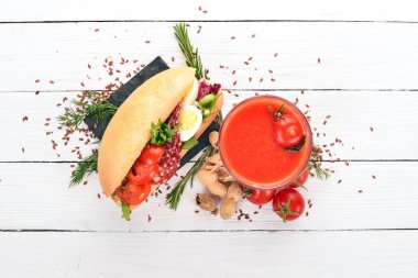 Kahvaltı. Domates suyu ve burger salam ve sebze. Ahşap bir arka plan üzerinde. Üstten Görünüm. Kopya alanı.