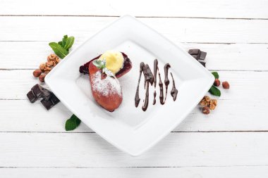 Tatlı. Karamelize armut bir plaka üzerinde dondurma ile. Ahşap bir arka plan üzerinde. Üstten Görünüm. Kopya alanı.