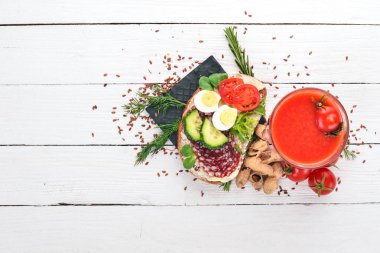 Kahvaltı. Domates suyu ve burger salam ve sebze. Ahşap bir arka plan üzerinde. Üstten Görünüm. Kopya alanı.