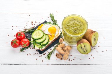 Kahvaltı. Kivi ve burger peynir bıldırcın yumurtası ve sebze ile. Ahşap bir arka plan üzerinde. Üstten Görünüm. Kopya alanı.