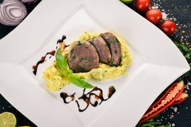 Dana dil bir tabak patates püresi ile haşlanmış. Ahşap bir arka plan üzerinde. Üstten Görünüm. Kopya alanı.