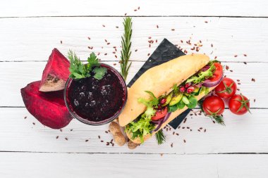 Kahvaltı. Pancar suyu ve avokado burger ve sebze. Ahşap bir arka plan üzerinde. Üstten Görünüm. Kopya alanı.